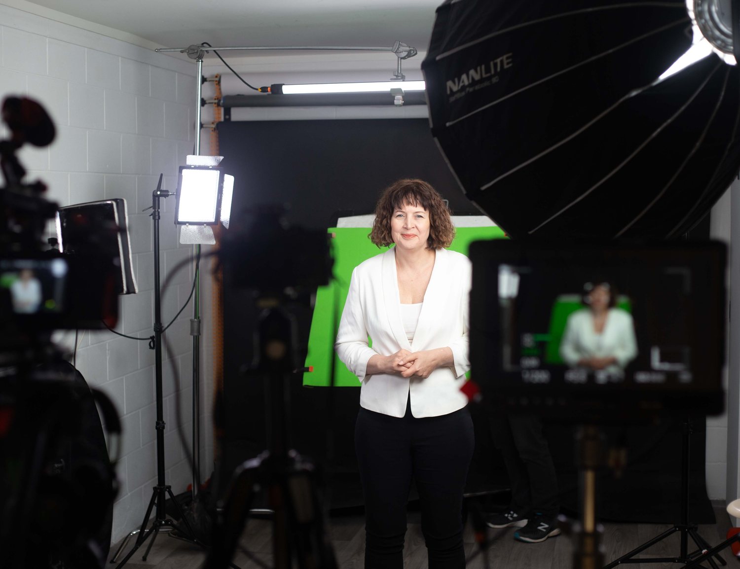 Behind the scenes of an AI video digital twin filming session, green screen and lighting rig