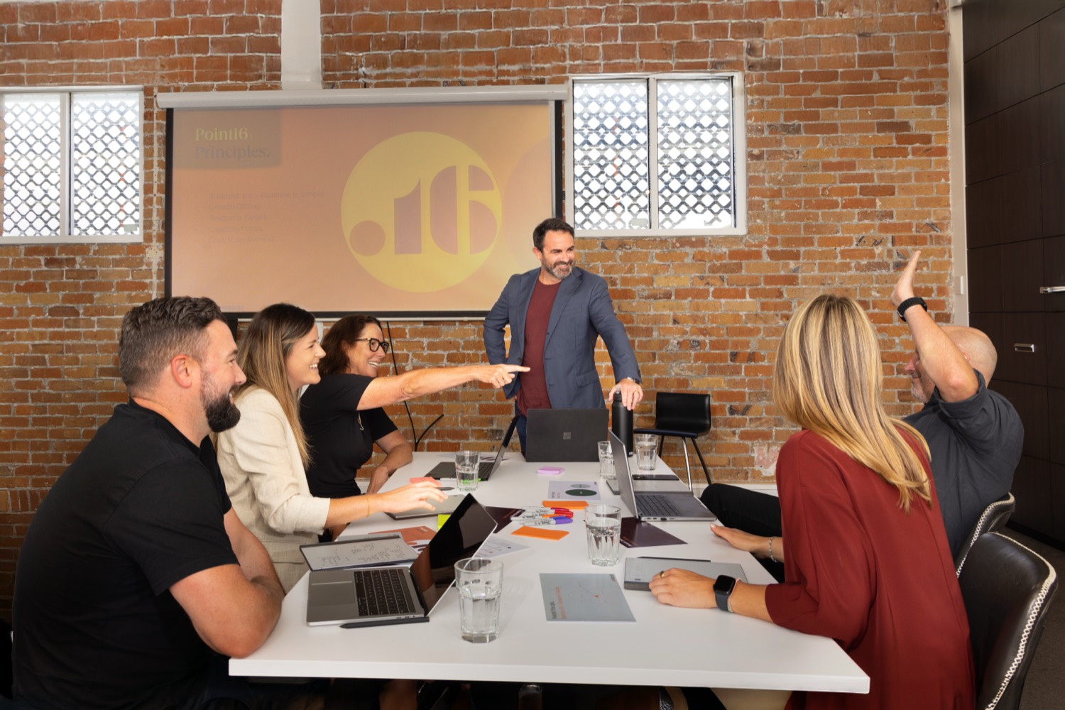 A team photographed mid meeting in their Auckland boardroom, showing how they work